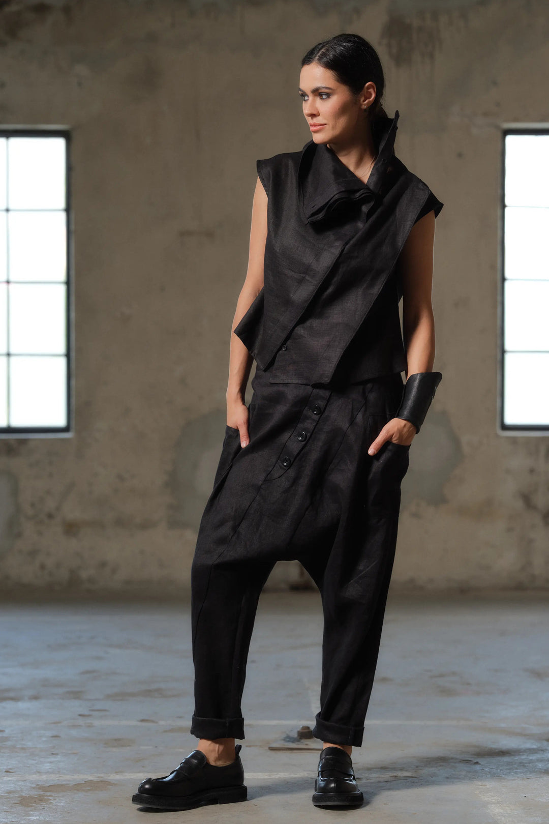 Close-up of the asymmetric button fastening on avant-garde linen pants